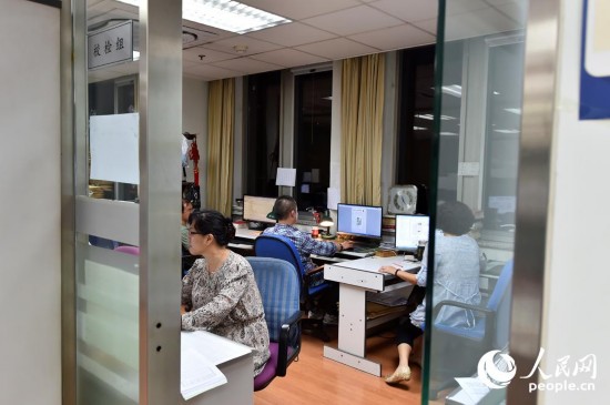 2015年6月11日23:25,人民日报校对员正在逐字逐句对报样进行校对.