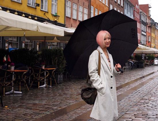 陈赫前妻晒旅游美照 穿风衣打伞发型变粉色短发