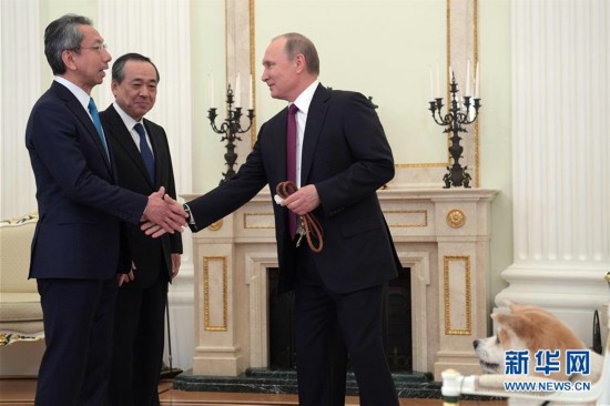 12月7日,俄罗斯总统普京(右)在莫斯科克里姆林宫与日本记者握手.
