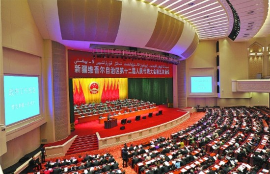 千人礼堂灯火辉煌,主席台帷幕中央国徽高悬,会场