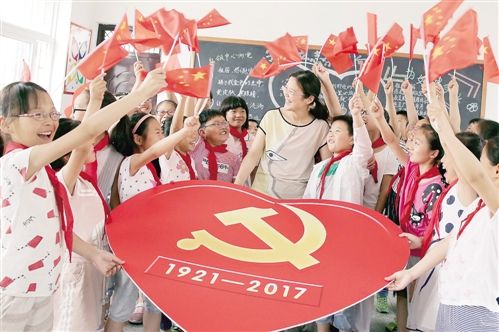 6月25日,江苏海安县南莫镇中心小学的老师为学生们讲解党徽知识.