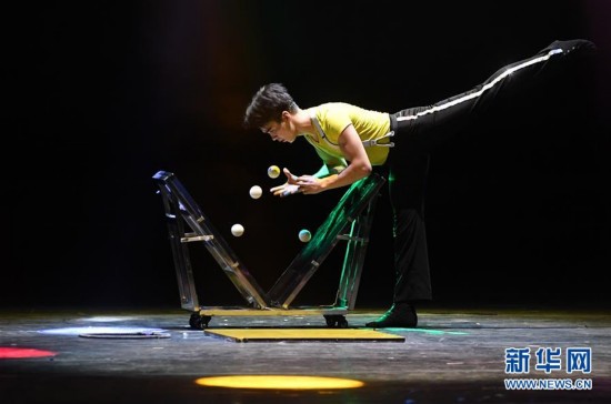 在新疆人民剧场,演员在表演杂技"弹球"项目(7月30日摄).