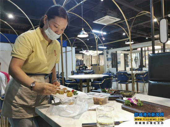 在一家餐厅内,服务员正在为顾客打包剩余的菜