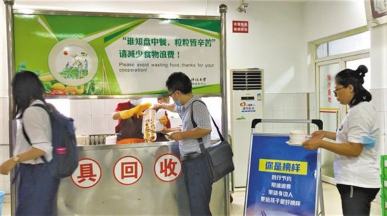 在西安科技大学骊山校区教职工餐厅餐具回收台,教师们有序排队放置