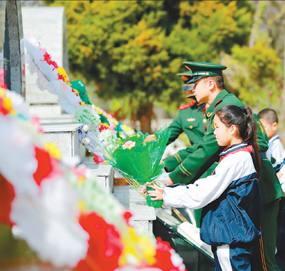 新疆伊犁州边防支队官兵和当地学生在伊宁市烈士陵园向革命先烈献花