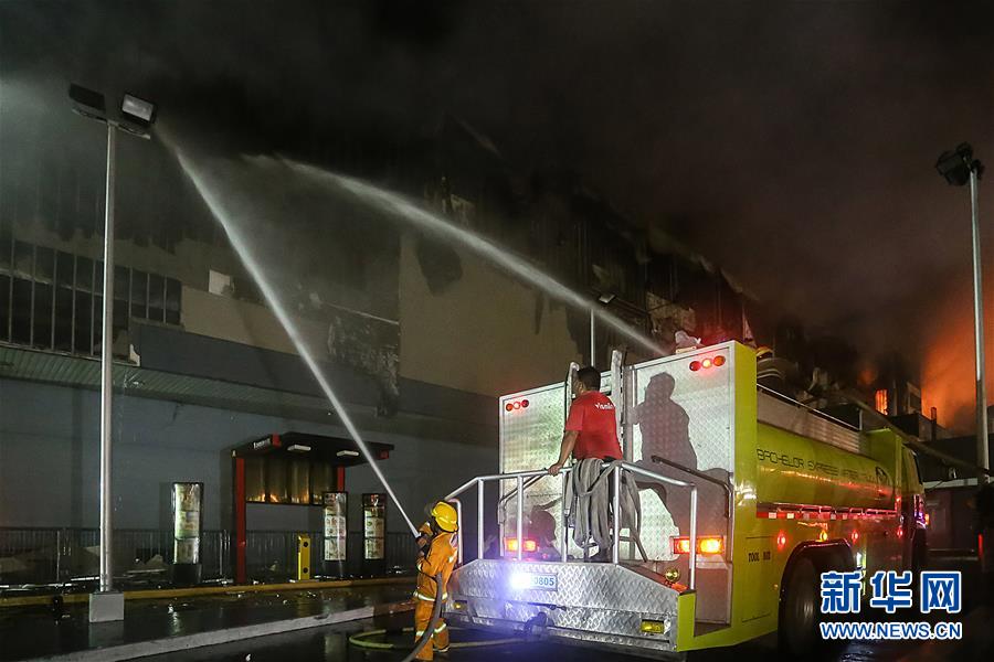 12月24日,在菲律宾南部城市达沃市,消防员在火灾现场灭火.