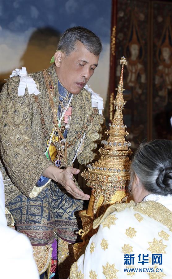泰国国王玛哈·哇集拉隆功在曼谷大王宫举行的加冕典礼上准备戴上王冠